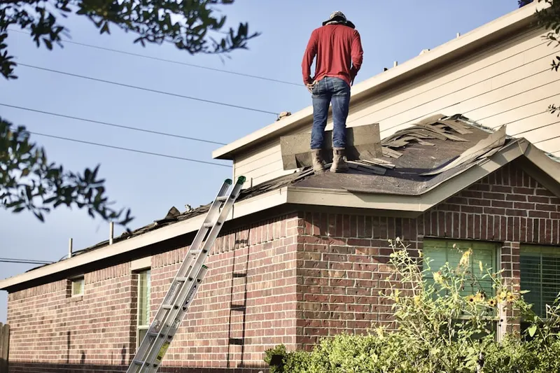 Professional roofer working on a residential roof in Stop